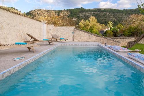 einen Pool im Hinterhof mit zwei Stühlen und einem Tisch in der Unterkunft Villa Tipica Casa Tua in Ragusa