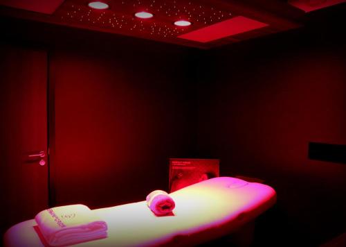 a bed in a room with a red room with avertisement at Hotel The Royal Snail in Namur