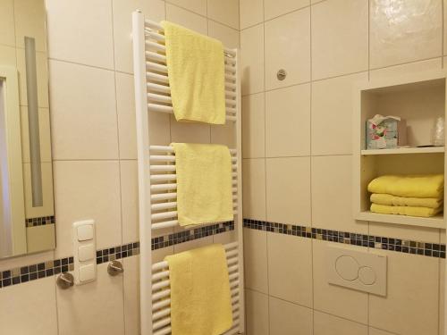 ein Badezimmer mit gelben Handtüchern auf einem Handtuchhalter in der Unterkunft Hotel Am Kuhbogen in Hof
