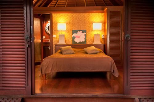 1 dormitorio con 1 cama con 2 almohadas en Robinson's Cove Villas en Papetoai