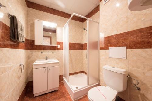 a bathroom with a shower and a toilet and a sink at GT Privilege Fort Beach Apartments in Elenite