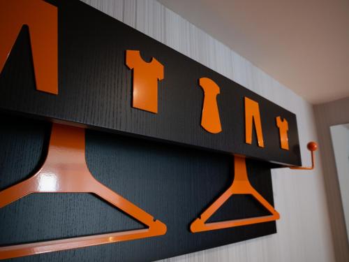 a black and orange clock on a wall at easyHotel Lisbon in Lisbon