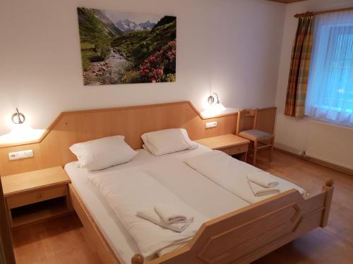a bedroom with a large bed with two lamps at Chalet Bergzauber by PiaundDirk in Hippach
