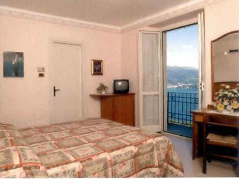 a bedroom with a bed and a large window at Hotel Brisino in Stresa