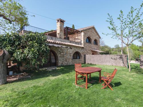 a table and two chairs in front of a house at Mas Teixidor in Crespiá