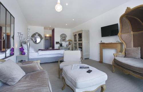 a living room with two beds and a couch at The Originals Hôtel Le Cise Restaurant Chambres et Suites in Ault