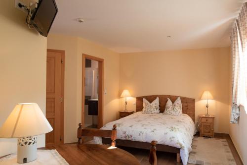 a bedroom with a bed and two lamps at La Ferme de Louise in Hohengoeft