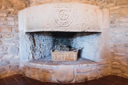 a stone fireplace with a basket in it at Mas Teixidor in Crespiá