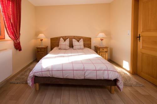 a bedroom with a large bed and two night stands at La Ferme de Louise in Hohengoeft