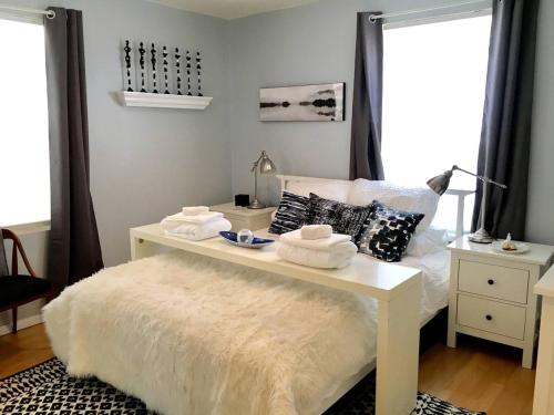 een slaapkamer met een wit bed en een tafel met handdoeken bij ~*30min to Downtown*~ THE COSMOPOLITAN in Boston