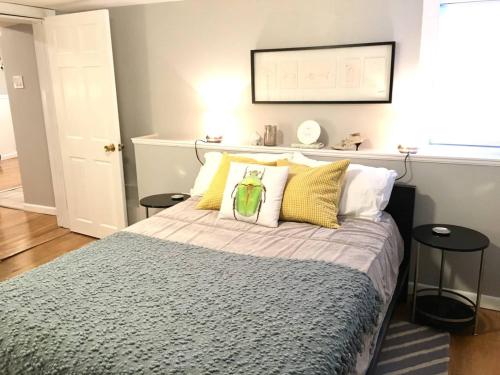 um quarto com uma cama com almofadas amarelas e brancas em ~*Pet Friendly 30min to Downtown*~ THE BOSTONIAN em Boston