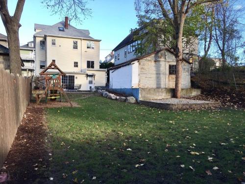 a yard with an old house and a playground at ~*Pet Friendly 30min to Downtown*~ THE BOSTONIAN in Boston