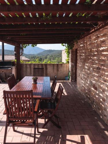 a wooden table and chairs on a patio at Mas Teixidor in Crespiá