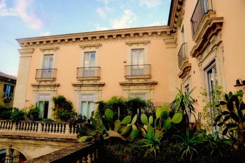 un edificio con balcones y plantas frente a él en Asmundo di Gisira, en Catania