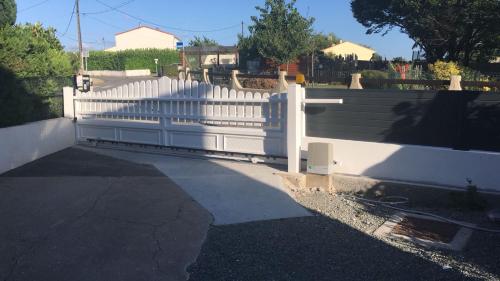a white fence in front of a driveway at Gite Au Cheval D'or in La Meilleraie-Tillay