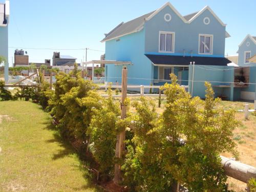 una fila de árboles frente a una casa azul en Complejo La Celeste en Playas Doradas