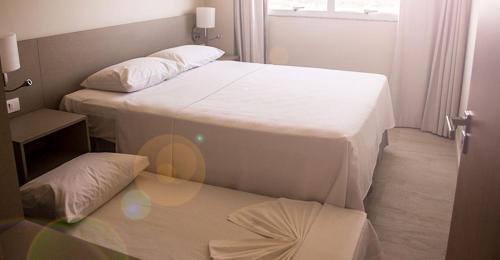 - 2 lits dans une petite chambre avec fenêtre dans l'établissement SALINAS PARK RESORT, à Salinópolis