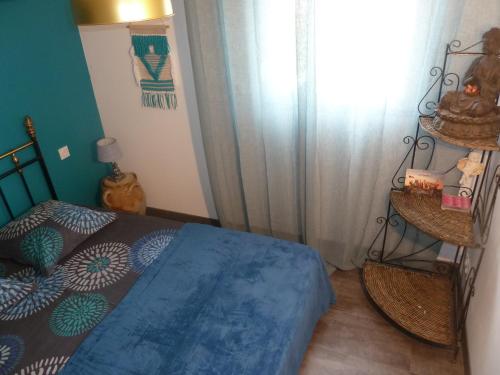 a bedroom with a blue bed and a window at Gite Au Cheval D'or in La Meilleraie-Tillay