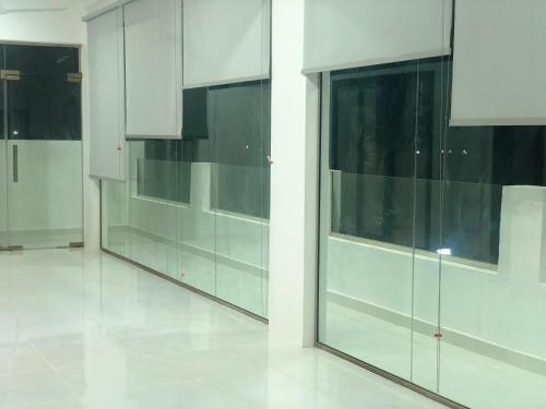 a kitchen with white cabinets and glass windows at Home X4 in Al Wāşil