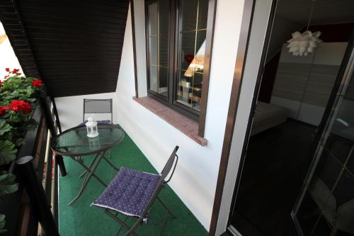 a small table and chair on a balcony at Ferienwohnung"Harzliebe" in Gernrode - Harz