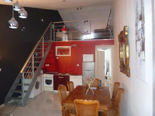 a kitchen and dining room with a table and a staircase at Gite Au Cheval D'or in La Meilleraie-Tillay