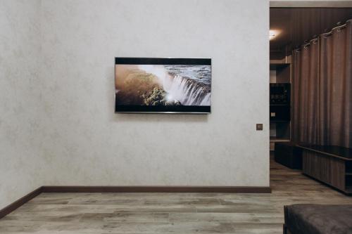 a television hanging on a wall in a room at Greatest Luxury Apartment in Sumy