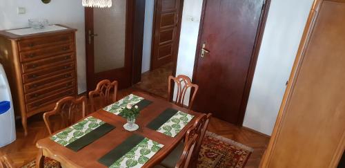 a dining room with a table and chairs and a room with a cabinet at Kikinda peace oaza in Kikinda