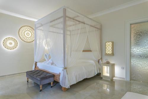 ein Schlafzimmer mit Himmelbett und Sessel in der Unterkunft Il Lusso Del Silenzio in Ugento