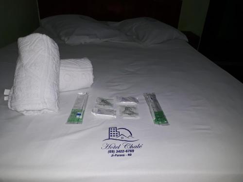 a white bed with towels and toilet paper on it at Hotel Chalé Ji-Parana in Ji-Paraná