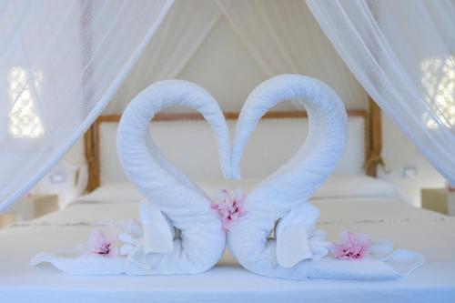 Dos toallas de cisne en una cama con dosel en Il Lusso Del Silenzio, en Ugento