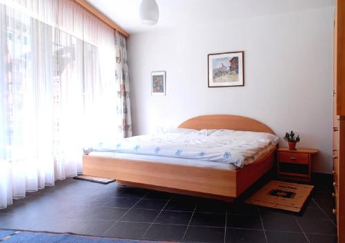Schlafzimmer mit einem Bett und einem Fenster in der Unterkunft Apartment Brunnmatt in Zermatt