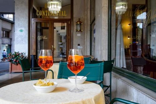 two wine glasses sitting on a table in a restaurant at Hotel Continental in Treviso