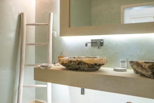 ein Badezimmer mit einem Steinwaschbecken auf der Theke in der Unterkunft Il Lusso Del Silenzio in Ugento