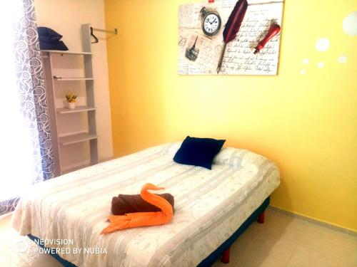 Un dormitorio con una cama con un juguete naranja. en Departamento "Sparanise", en Playa del Carmen