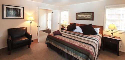 1 dormitorio con 1 cama y 1 silla en Pine Acres Lodge, en Pacific Grove