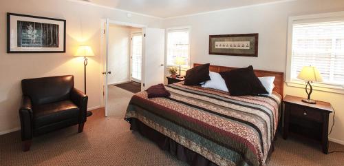a bedroom with a bed and a chair at Pine Acres Lodge in Pacific Grove
