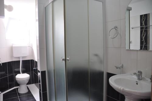 a bathroom with a shower and a toilet and a sink at Villa Bella Boutique Hotel in Kavadarci