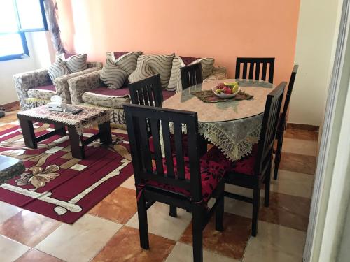 a dining room with a table and chairs and a couch at Cozy new 2 BD Amazing beach view Next to Hilton hotel Family only !العائلات فقط in Alexandria