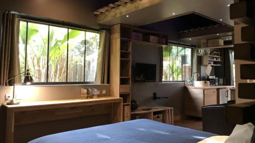 a bedroom with a bed and a large window at Tchankéklass in Le Teich