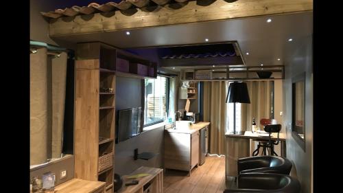 a living room with a leather chair and a desk at Tchankéklass in Le Teich