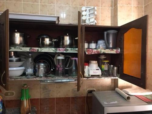 a kitchen with a shelf with pots and pans at Cozy new 2 BD Amazing beach view Next to Hilton hotel Family only !العائلات فقط in Alexandria