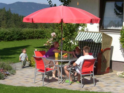 a group of people sitting at a table under an umbrella at Gästehaus Elisabeth in Radstadt