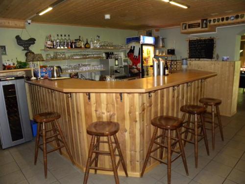 a wooden bar with stools in a kitchen at Hotel Restaurant Walliser Sonne in Reckingen - Gluringen