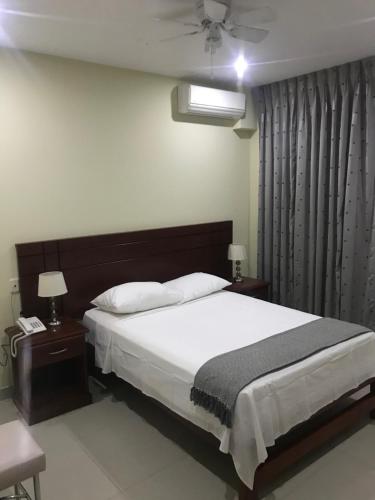 a bedroom with a large bed and two night stands at LC Hoteles Piura in Piura