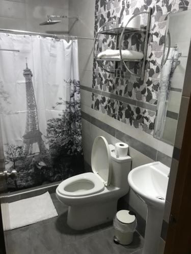 a bathroom with a toilet and a sink with the eiffel tower at LC Hoteles Piura in Piura