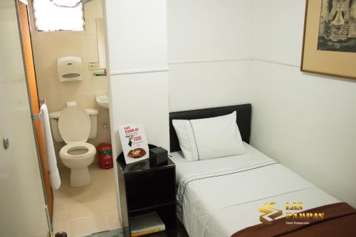Habitación pequeña con cama y aseo en Hotel Las Rampas, en Medellín