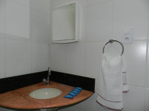 a bathroom with a sink and a roll of paper towels at APARTAMENTOS NO CENTRO DE BRASILIA. in Brasilia