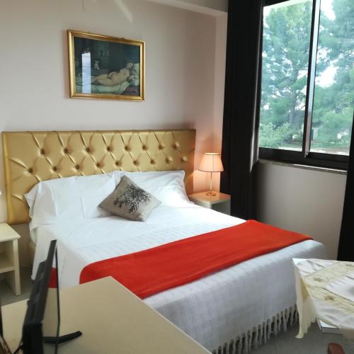 a bedroom with a bed with a red blanket at B&B la Maison in Sammichele di Bari