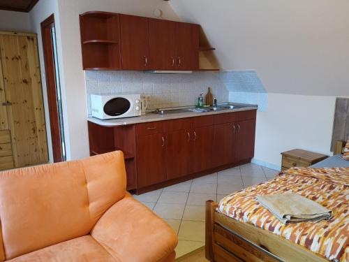 a kitchen with a stove and a microwave at Apartman116 Airport in Vecsés