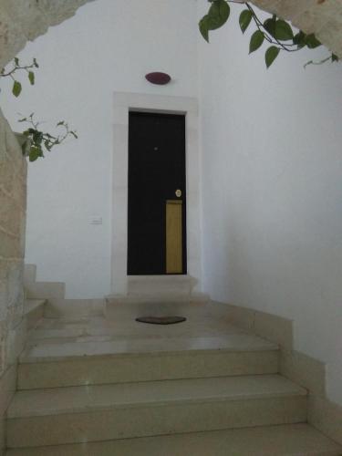 a stairway with a black door and a black door sidx sidx sidx at ARCOBELLO Suite Rooms in Castellana Grotte